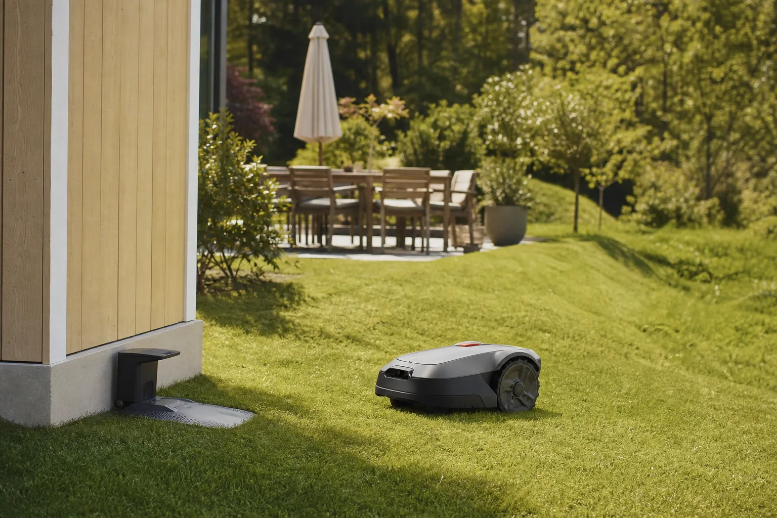 Robotgräsklippare som klipper en svensk villatomt med kuperad gräsmatta